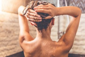 Woman running a glossing treatment through wet hair